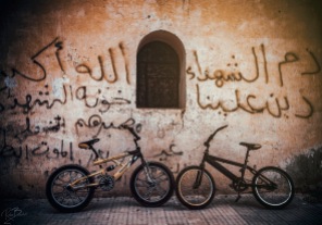 The kids left their bikes in front of an old church's wall which is sprayed on "Martyr's blood is good on us", "The fate of traitors of the martyrs is slow death" and "God is the greatest" while the kids are playing Volleyball inside the old church.